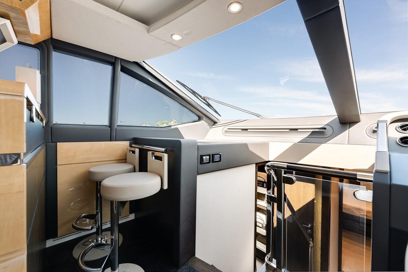 a room with a window and stools and a view of the water aboard TRUTH SERUM Yacht for Sale