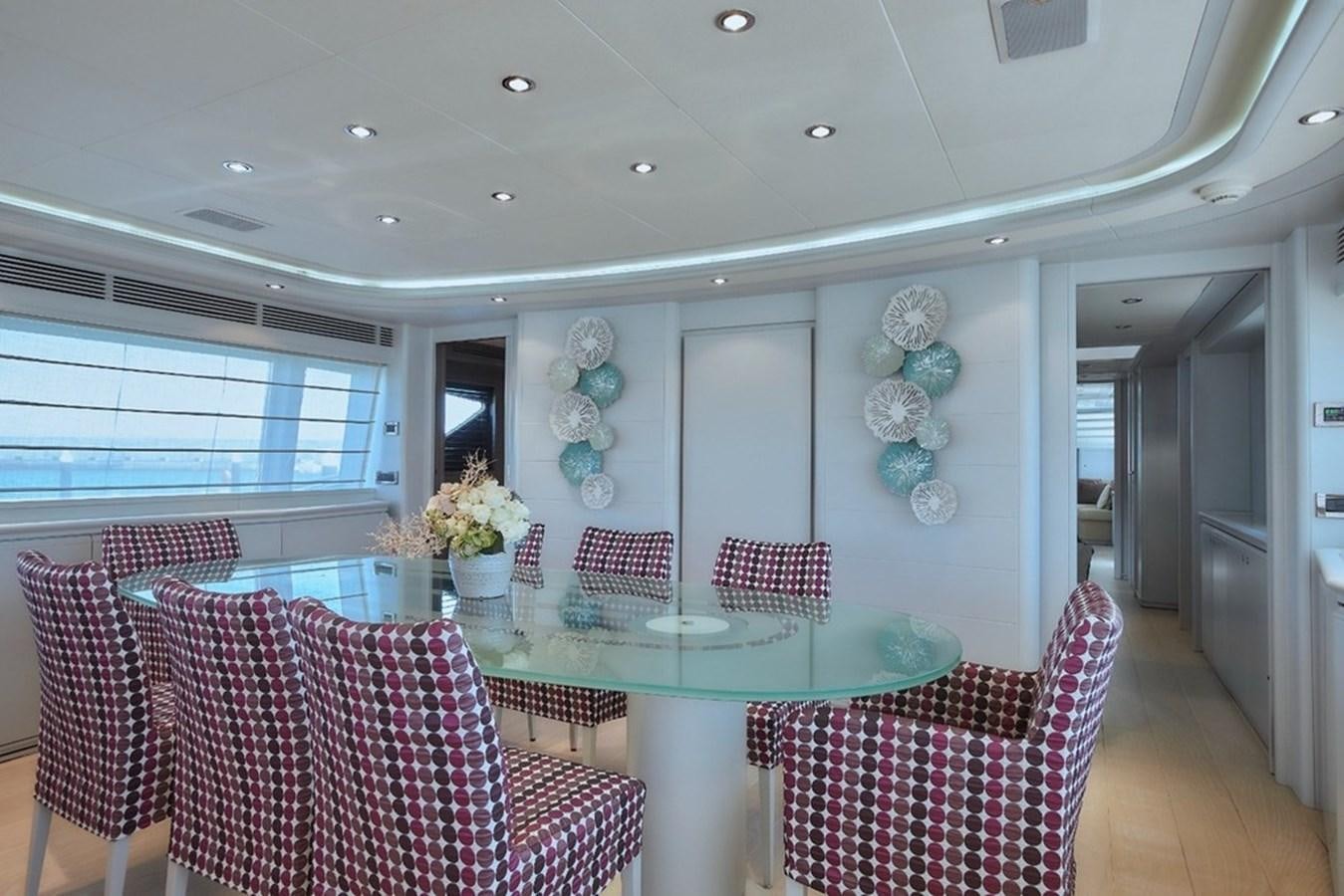 a room with a table chairs and flowers aboard CAMARIK Yacht for Sale