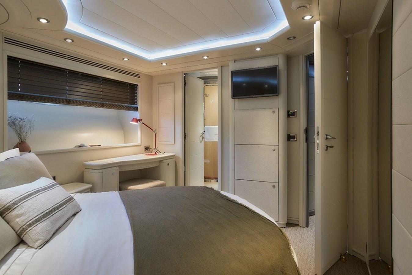 a bedroom with a bed and a television on the wall aboard CAMARIK Yacht for Sale