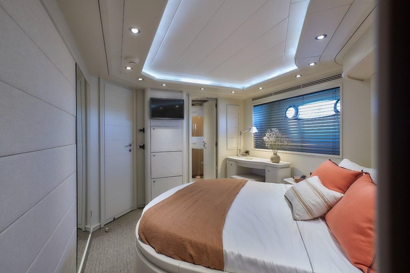a bedroom with a bed and a desk aboard CAMARIK Yacht for Sale