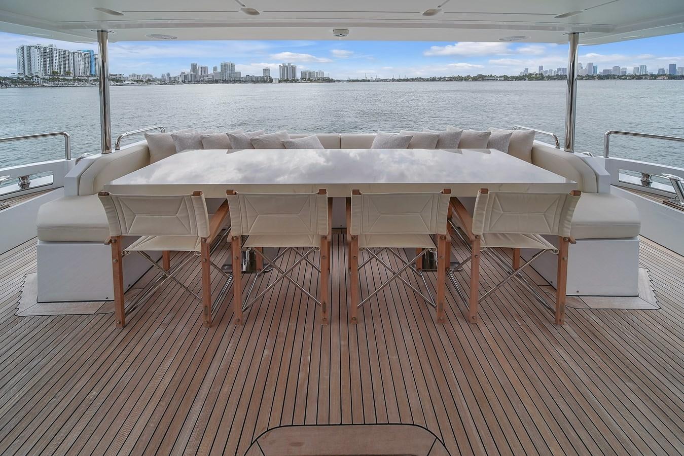 a table and chairs on a deck aboard 95 RAISED PILOTHOUSE Yacht for Sale
