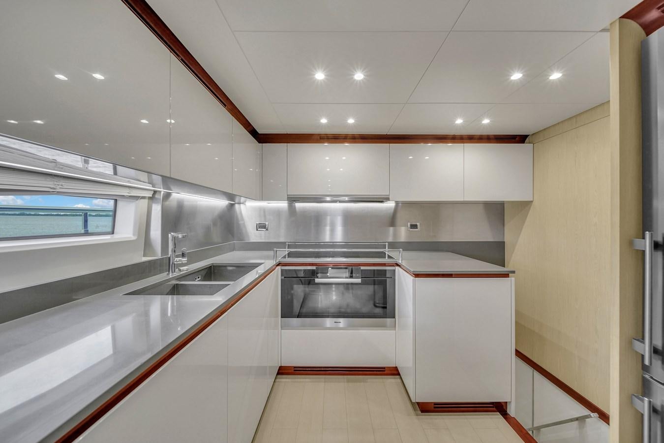 a kitchen with white cabinets aboard 95 RAISED PILOTHOUSE Yacht for Sale