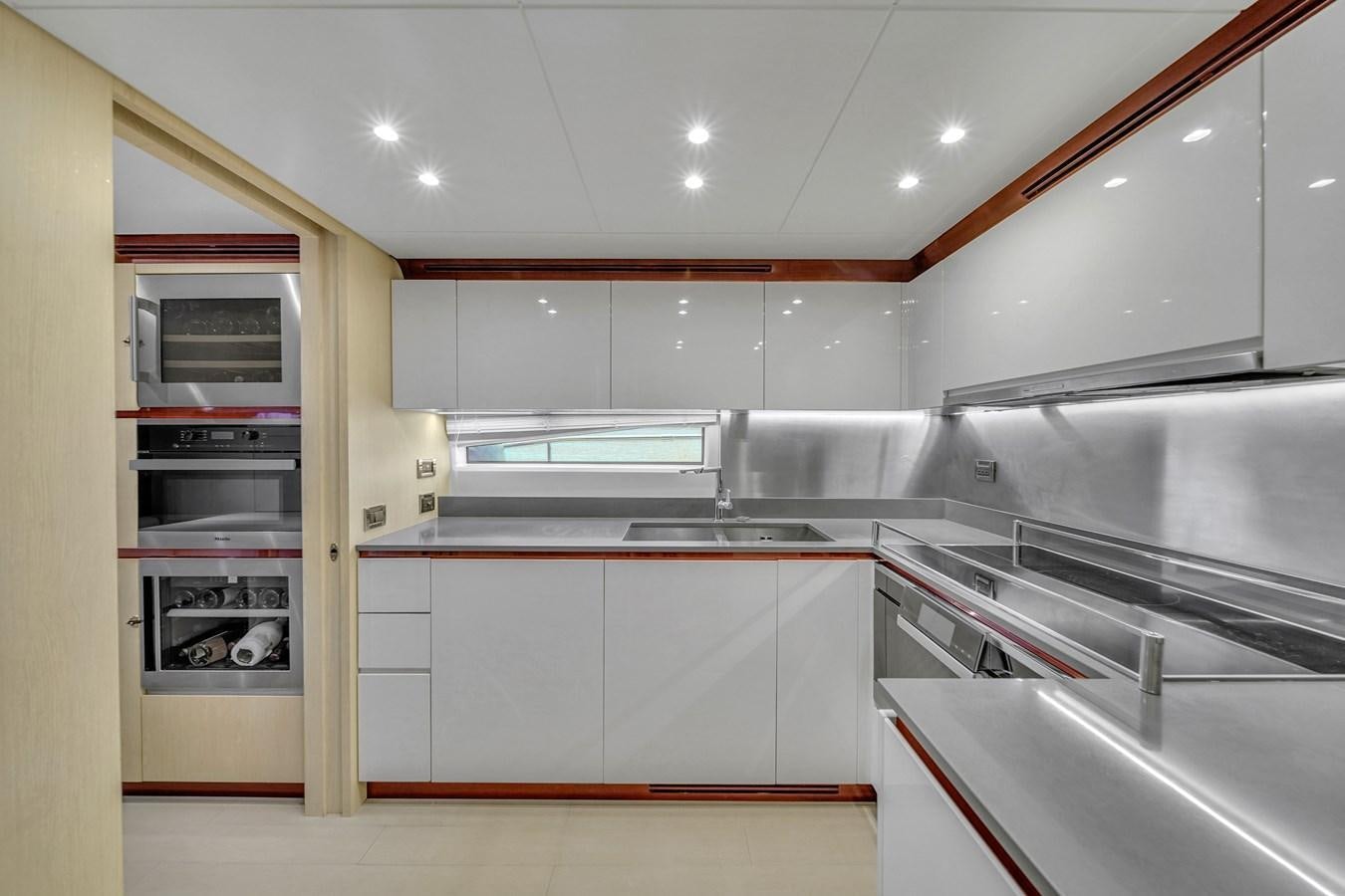 a kitchen with white cabinets aboard 95 RAISED PILOTHOUSE Yacht for Sale