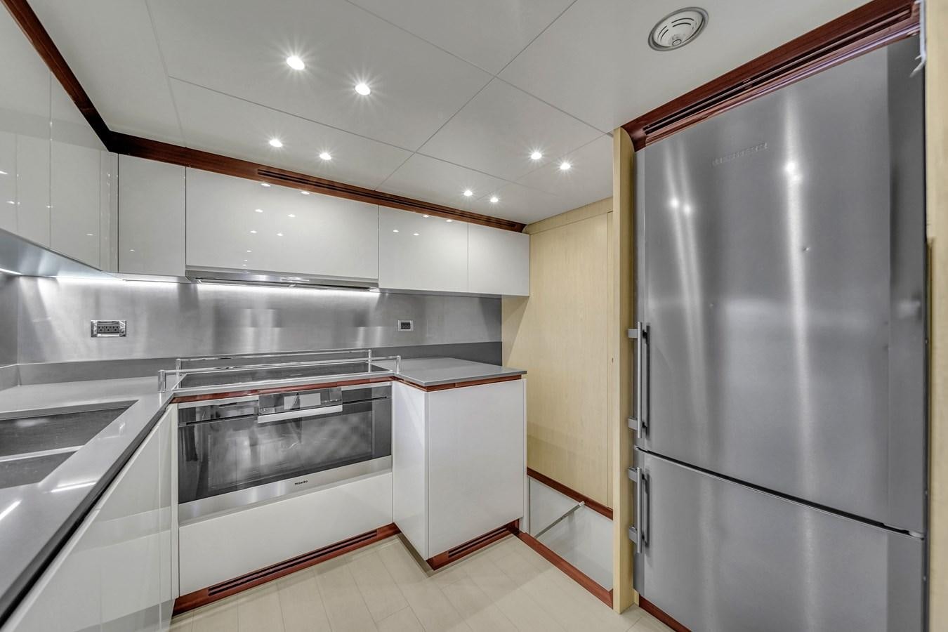 a kitchen with white cabinets aboard 95 RAISED PILOTHOUSE Yacht for Sale