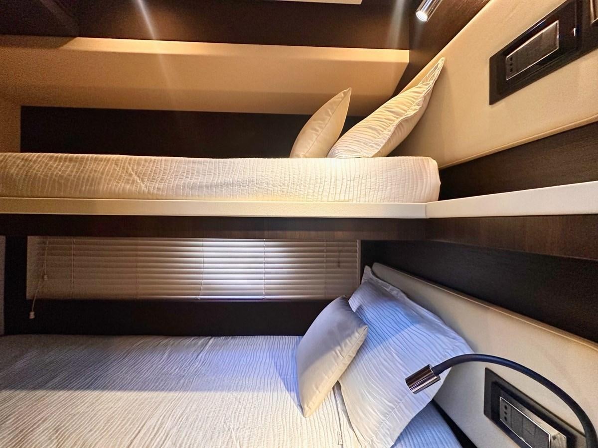 a bed with a white sheet and a wooden headboard aboard TAMARA II Yacht for Sale