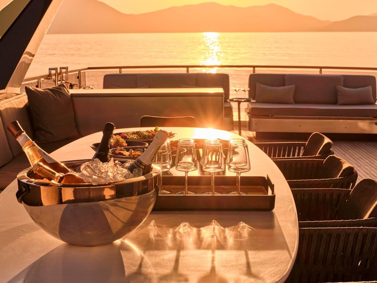 a table with a bowl of food and a glass of wine on it aboard SEAMMETRY Yacht for Sale