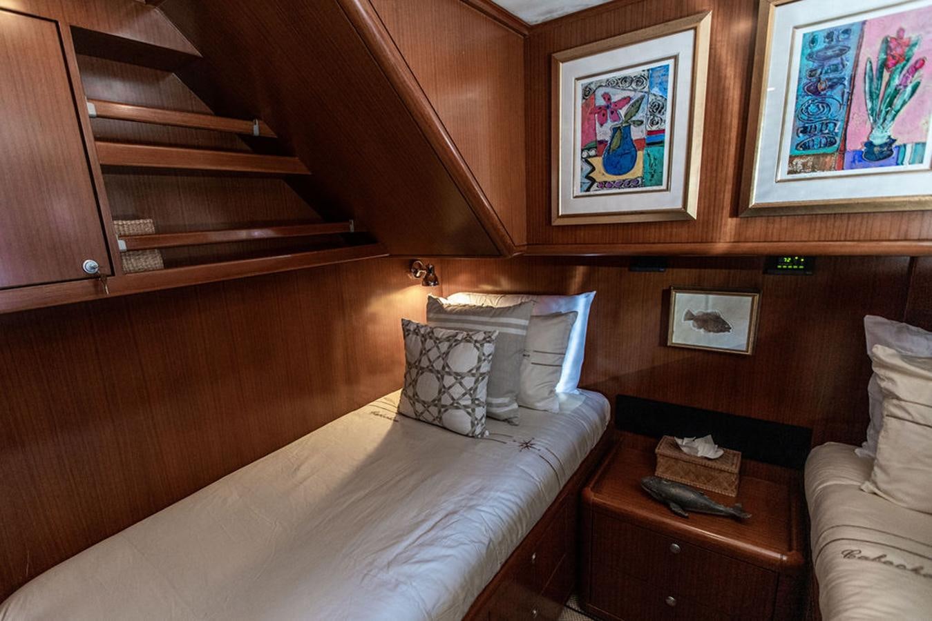 a bed with a wooden headboard aboard CABOCHON Yacht for Sale