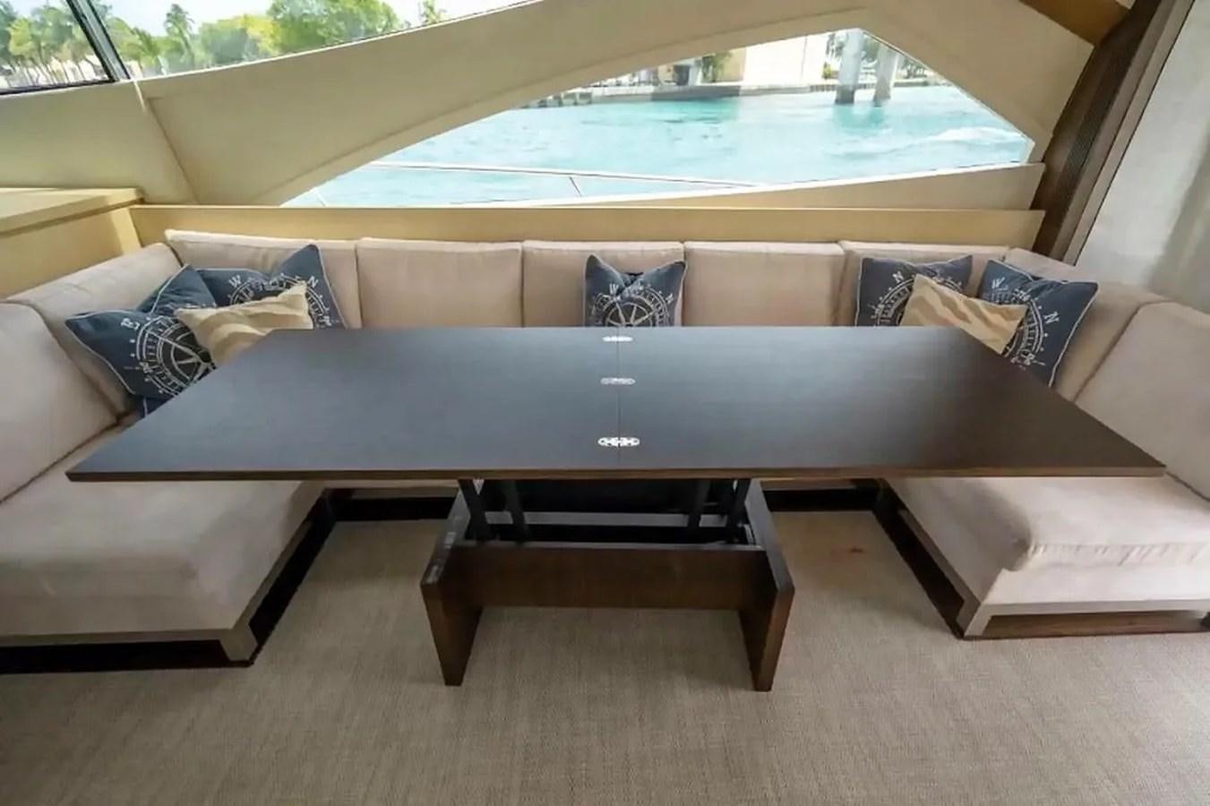 a couch with a table and a window aboard BELLA VITA Yacht for Sale