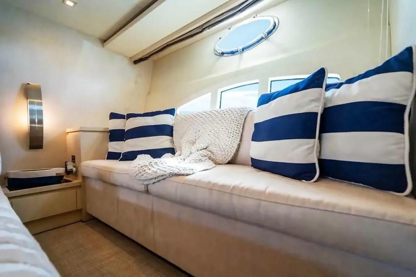 a bed with blue and white pillows aboard BELLA VITA Yacht for Sale