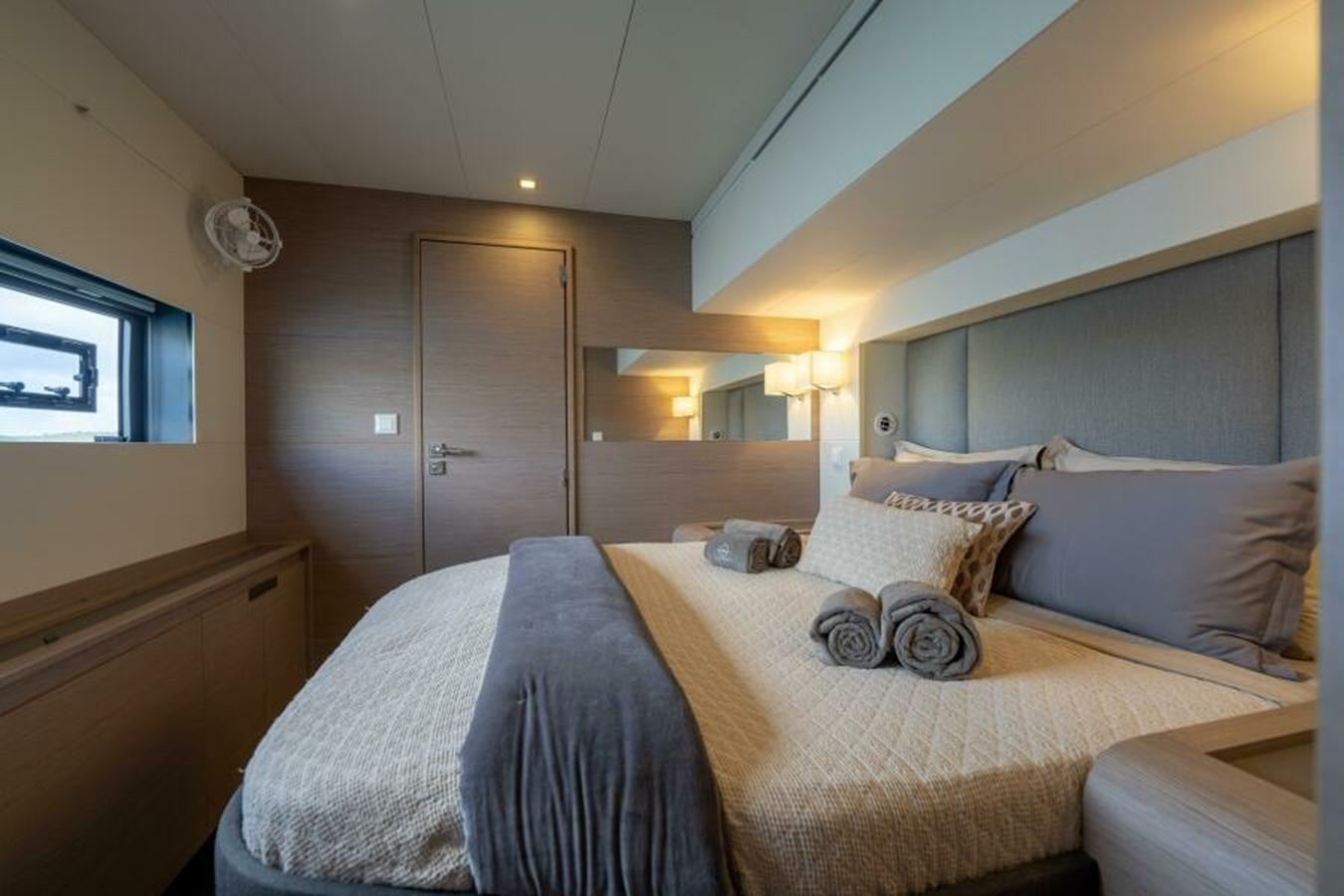 a bed with a white comforter aboard 2022 FOUNTAINE PAJOT POWER 67 Yacht for Sale