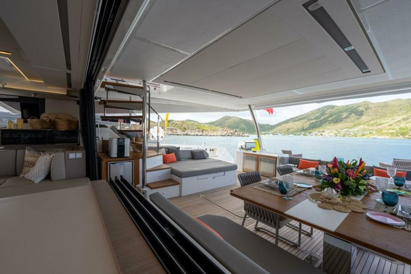 a room with a table and couches aboard 2022 FOUNTAINE PAJOT POWER 67 Yacht for Sale