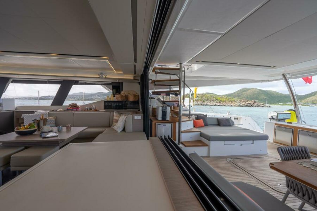 a room with a couch and a table aboard 2022 FOUNTAINE PAJOT POWER 67 Yacht for Sale