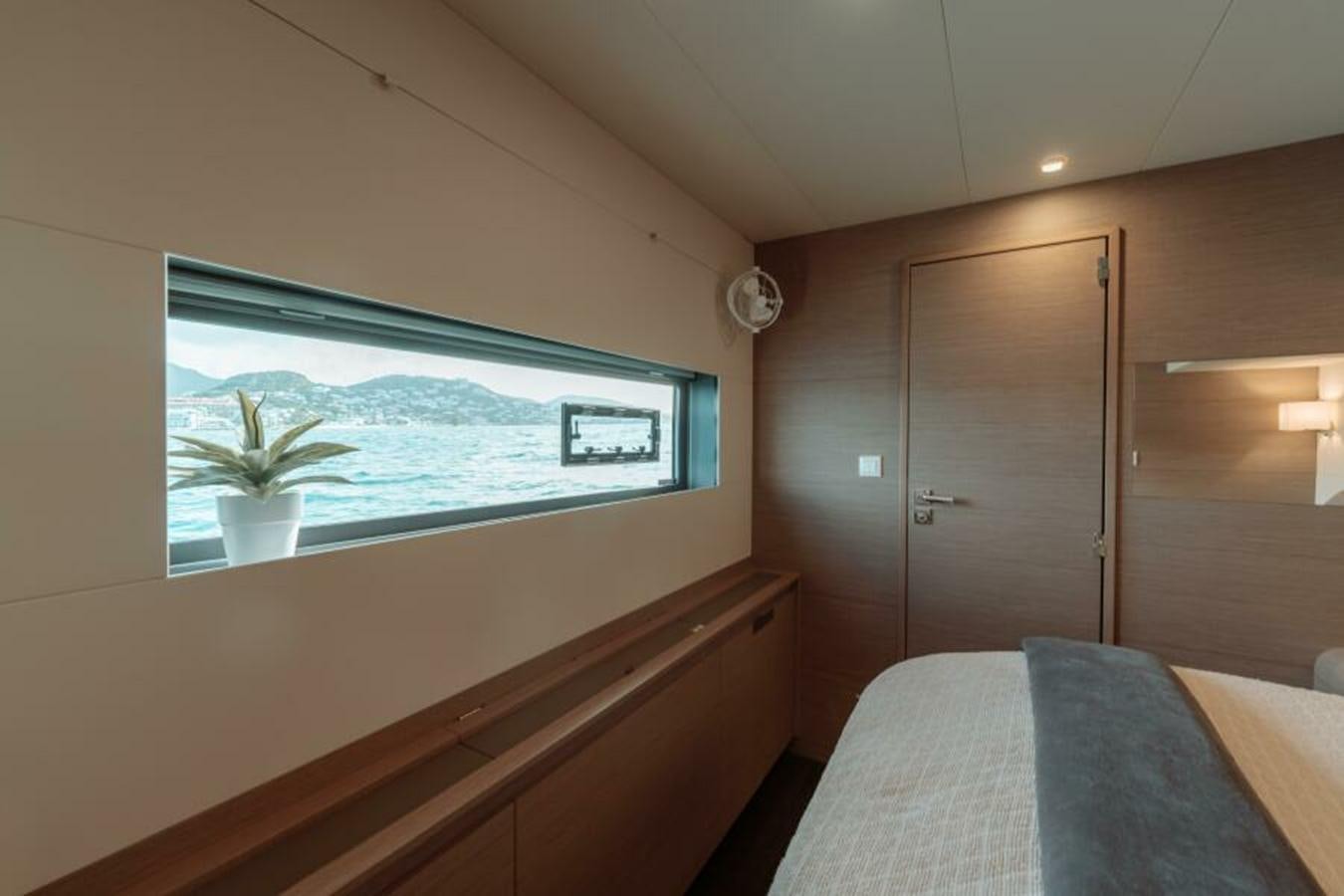 a room with a bed and a window aboard 2022 FOUNTAINE PAJOT POWER 67 Yacht for Sale
