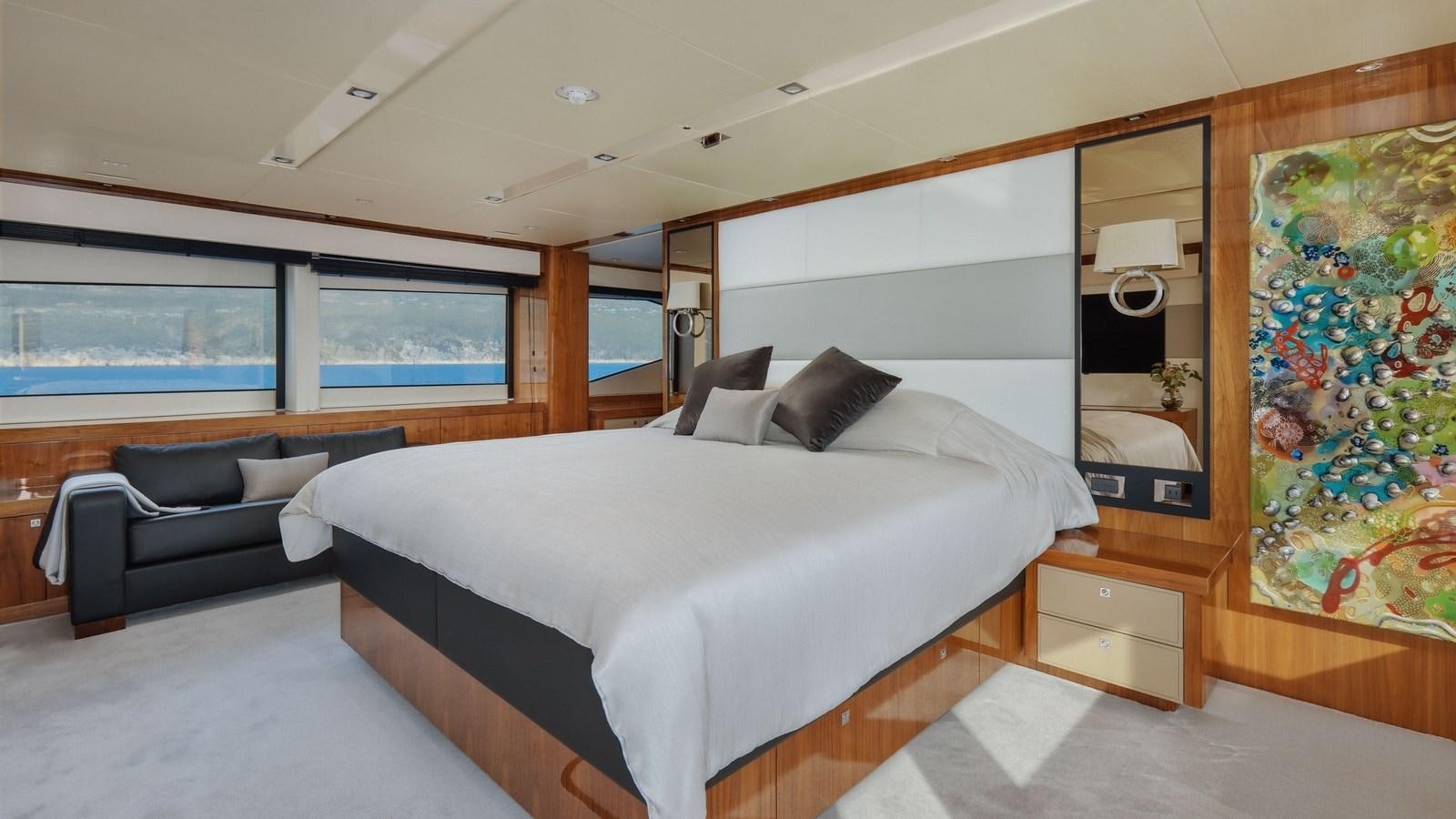 a bedroom with a bed and a couch aboard WICKED PLAY Yacht for Sale
