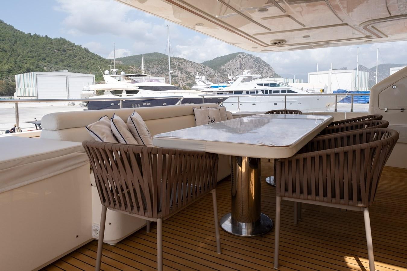 a deck with a table and chairs aboard BLEU BLANC Yacht for Sale