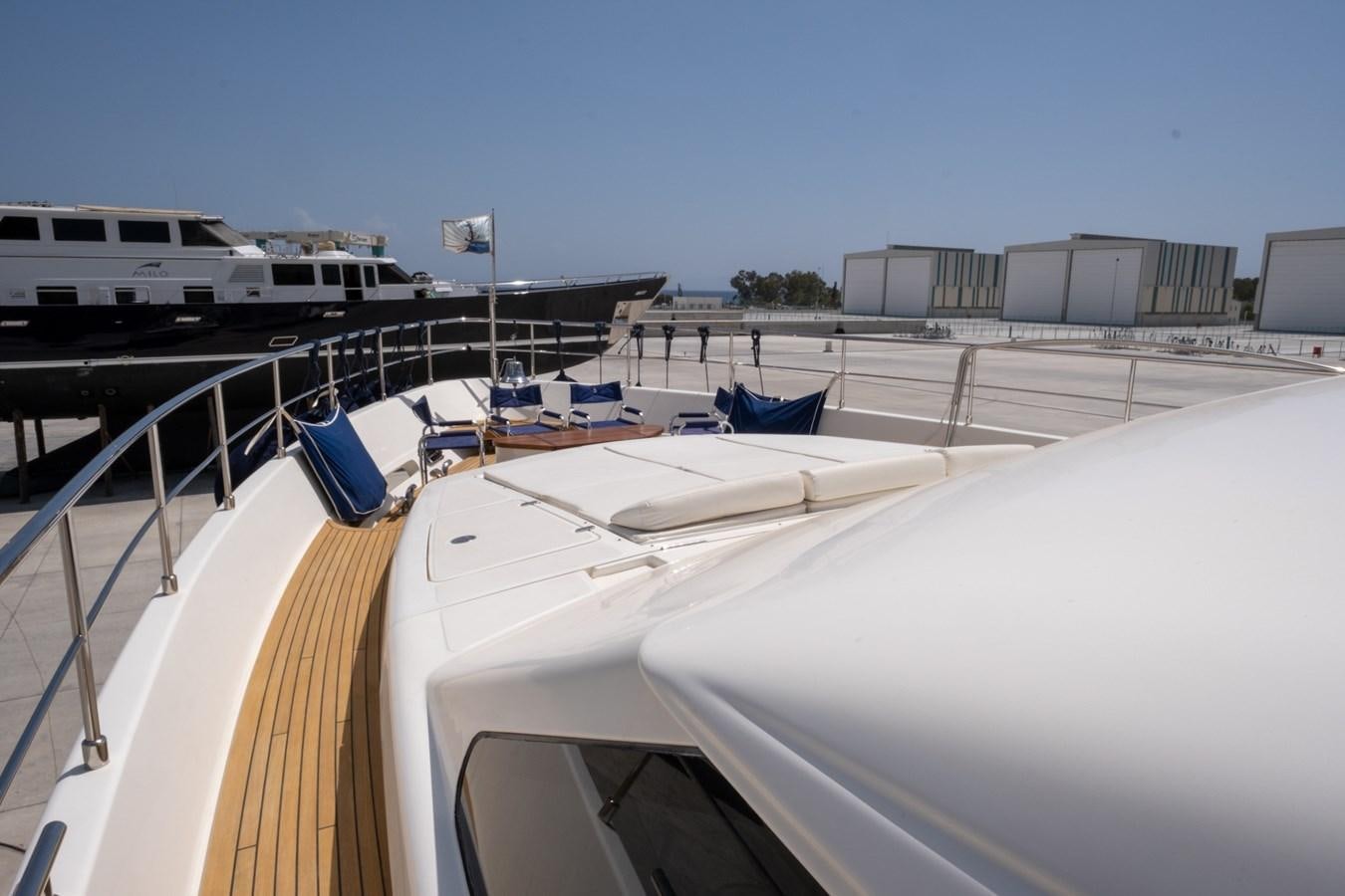 a deck with a boat and a building in the background aboard BLEU BLANC Yacht for Sale
