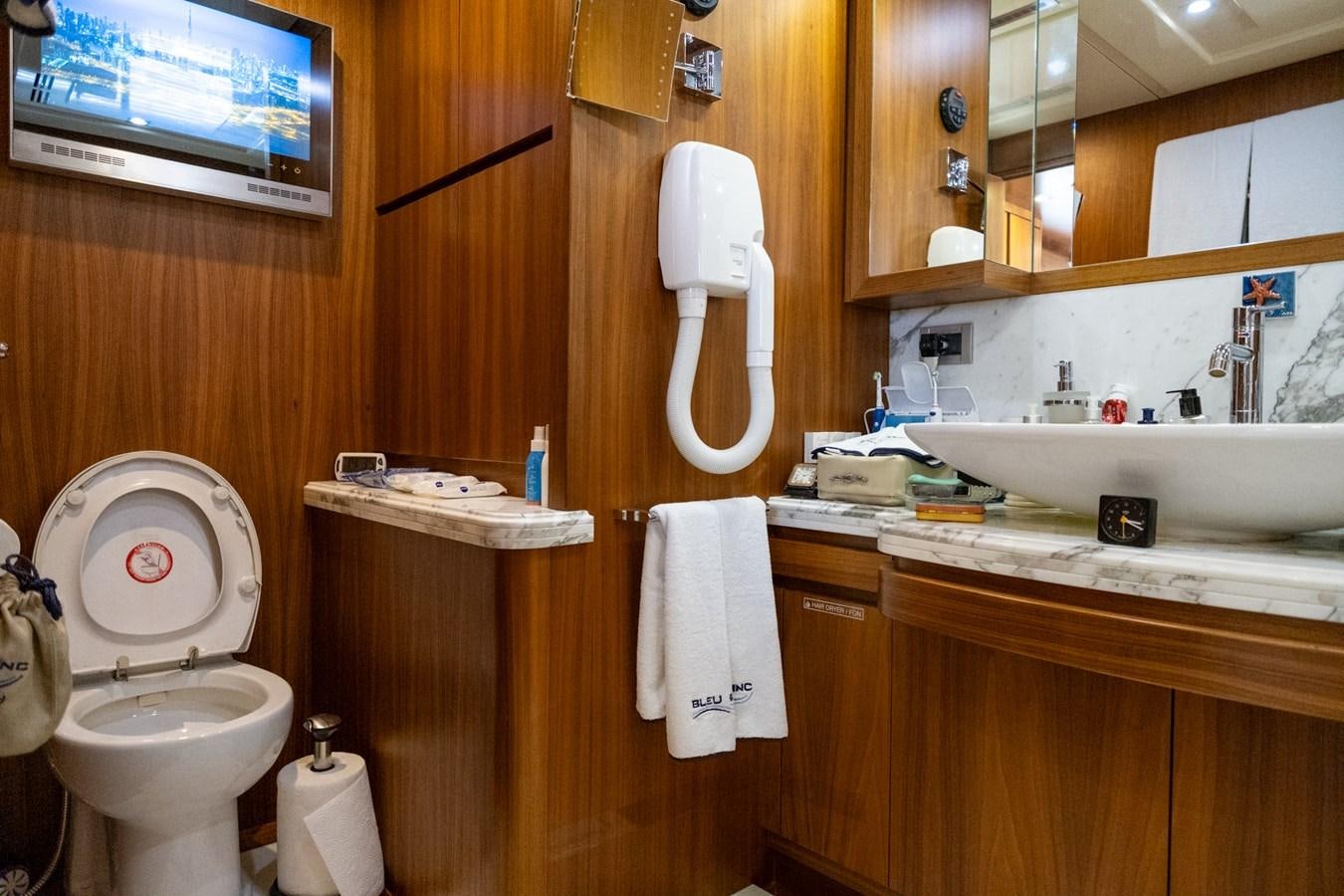 a bathroom with a toilet and a sink aboard BLEU BLANC Yacht for Sale