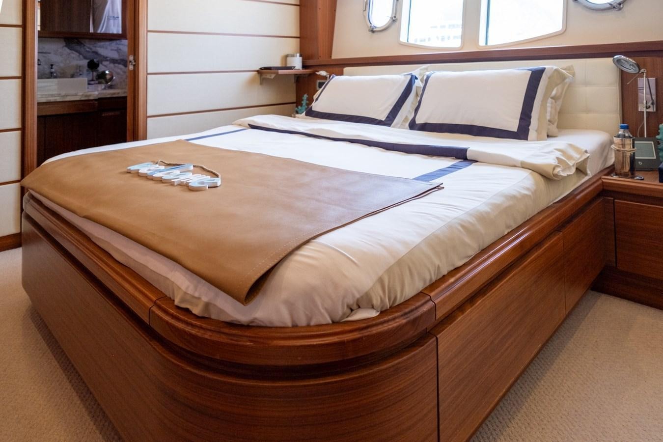 a bed with a wooden frame aboard BLEU BLANC Yacht for Sale