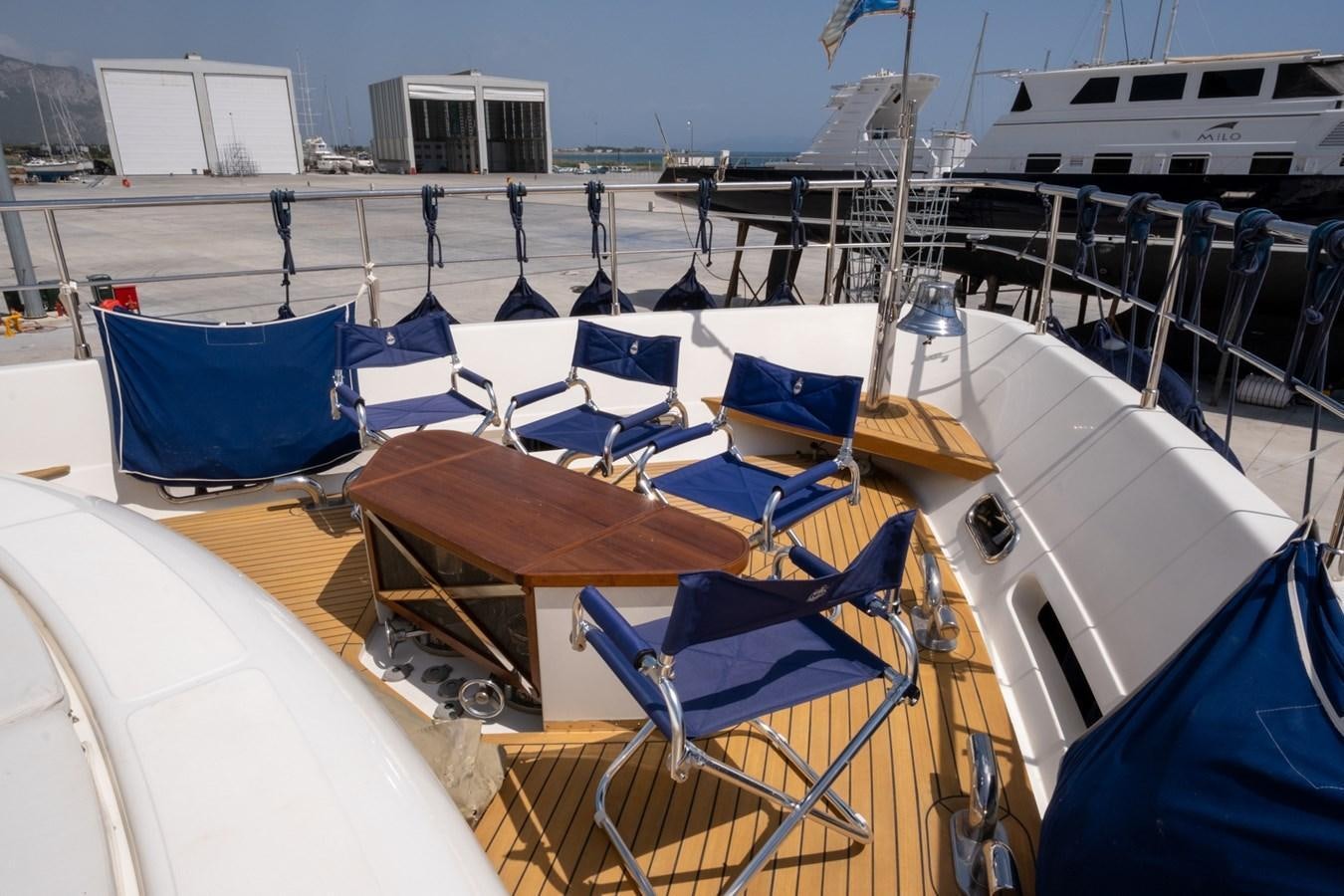 a deck with a table and chairs on it aboard BLEU BLANC Yacht for Sale