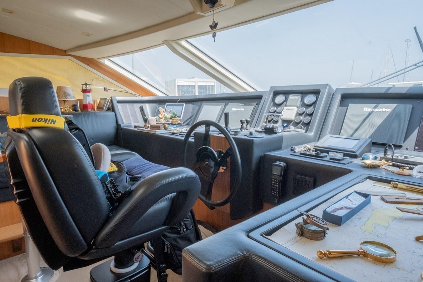 a car with a seat belt and a desk with a computer and other items on it aboard BLEU BLANC Yacht for Sale