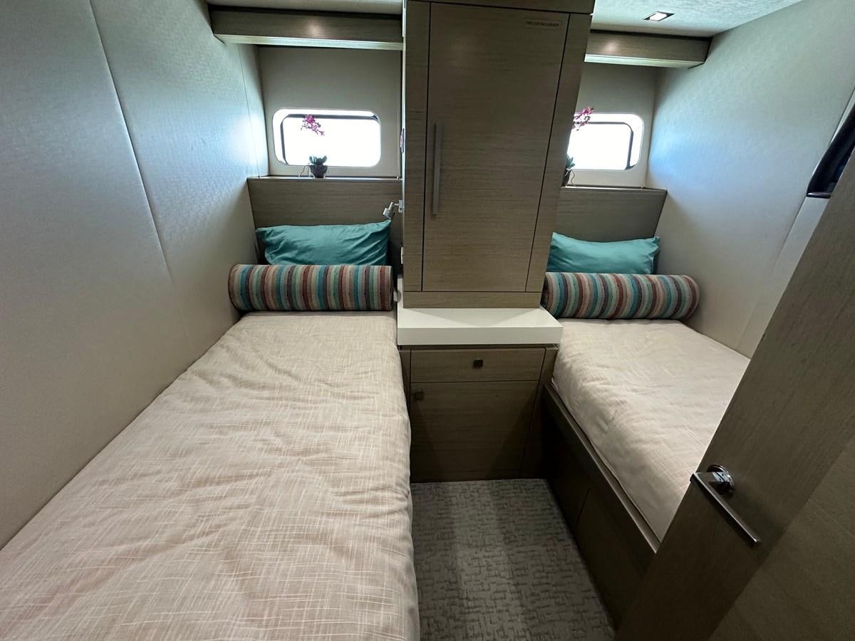 a room with a bed and a dresser aboard WATER RODEO Yacht for Sale
