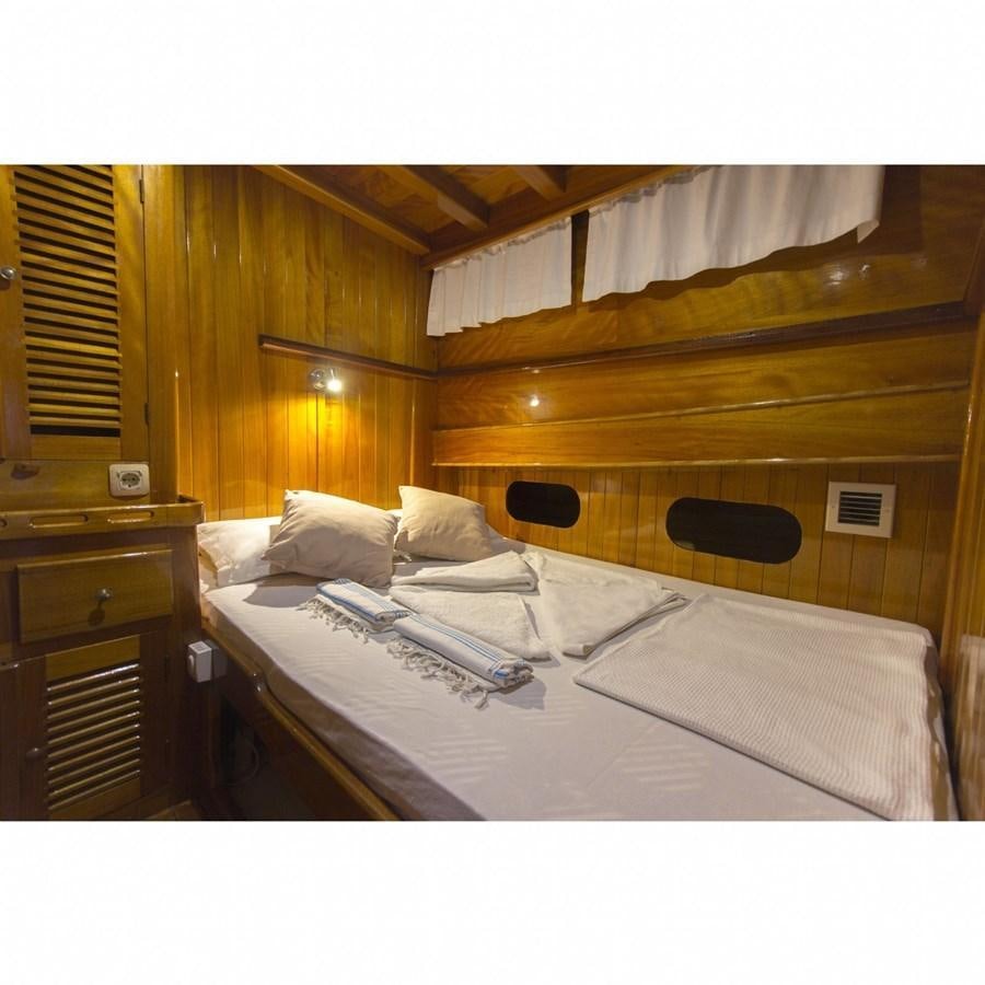 a room with a bed and a wood wall aboard NEMESIS Yacht for Sale