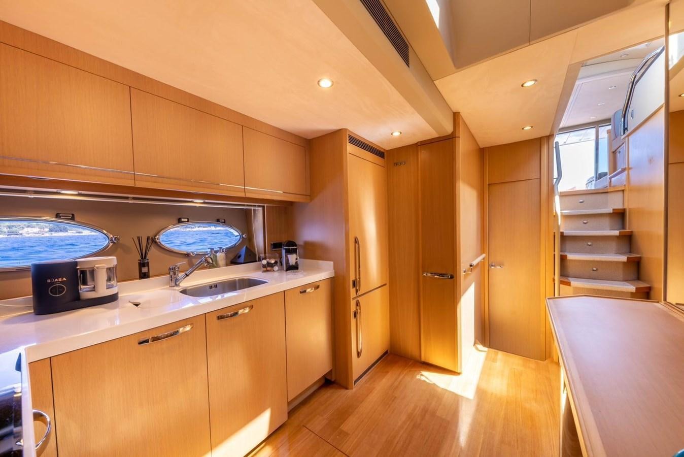 a kitchen with wooden cabinets aboard PRINCESS V70 Yacht for Sale