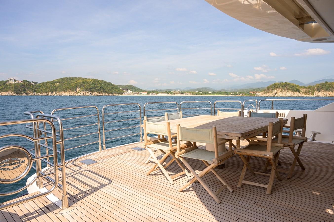 a deck with chairs and tables on it by a body of water aboard M5 Yacht for Sale