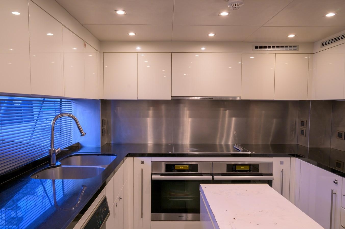 a kitchen with white cabinets aboard M5 Yacht for Sale