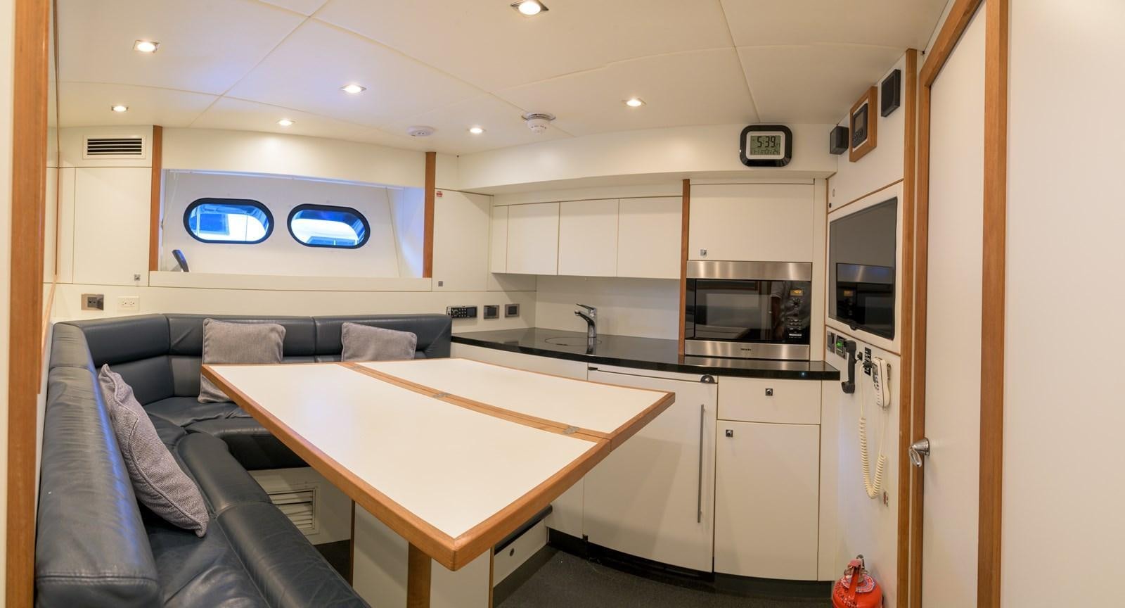 a kitchen with a couch and a table aboard M5 Yacht for Sale