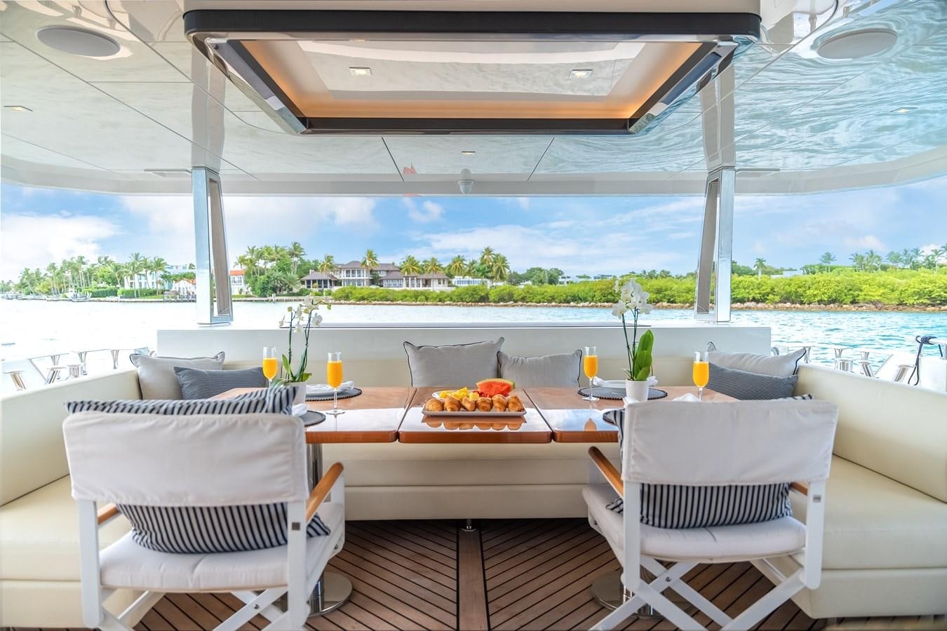 a table with chairs and a view of the water aboard JUST A VACATION Yacht for Sale