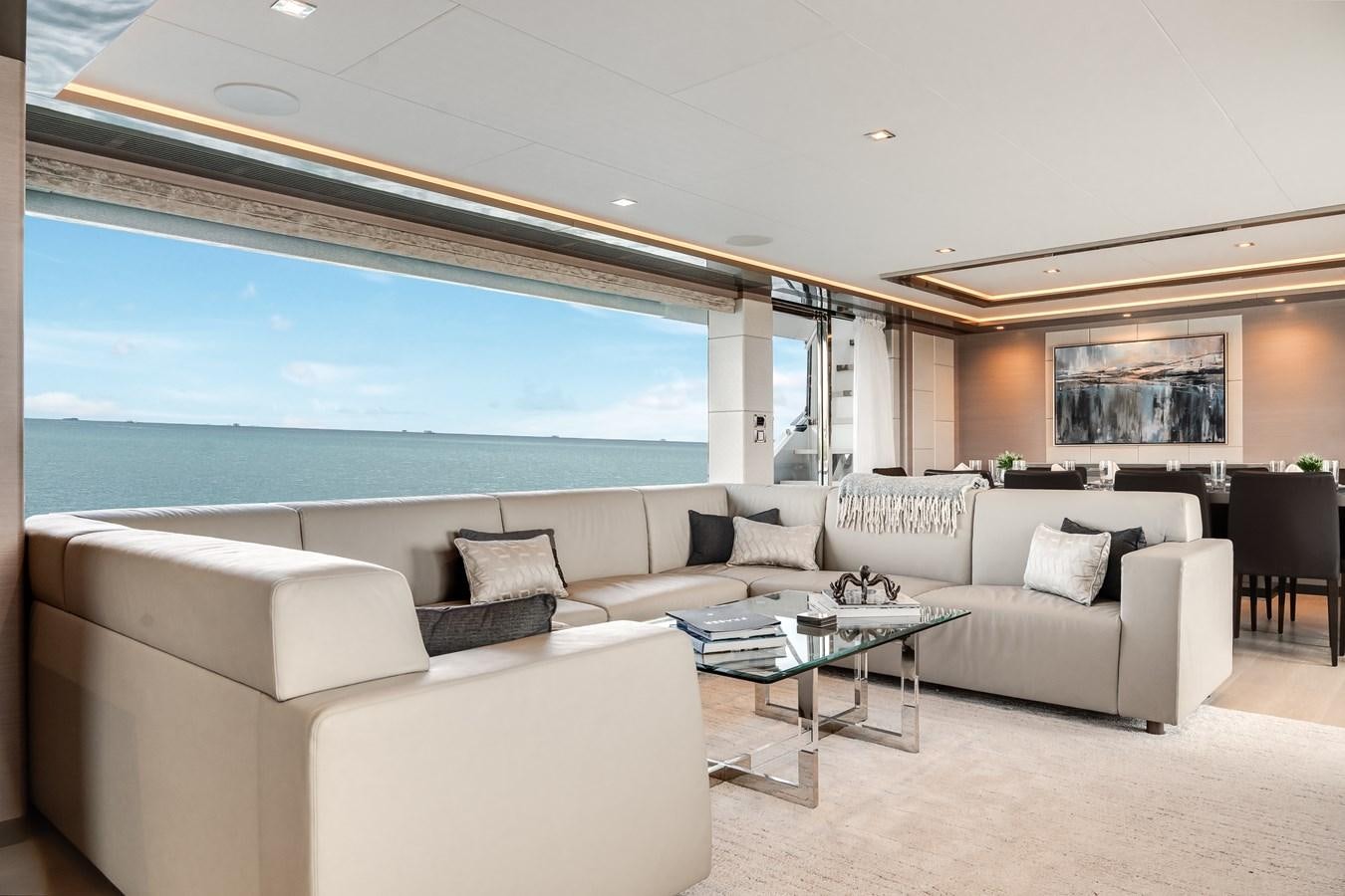 a living room with a large blue ocean aboard JUST A VACATION Yacht for Sale