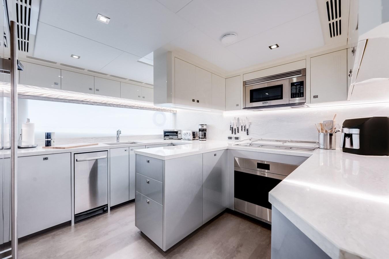 a kitchen with white cabinets aboard JUST A VACATION Yacht for Sale
