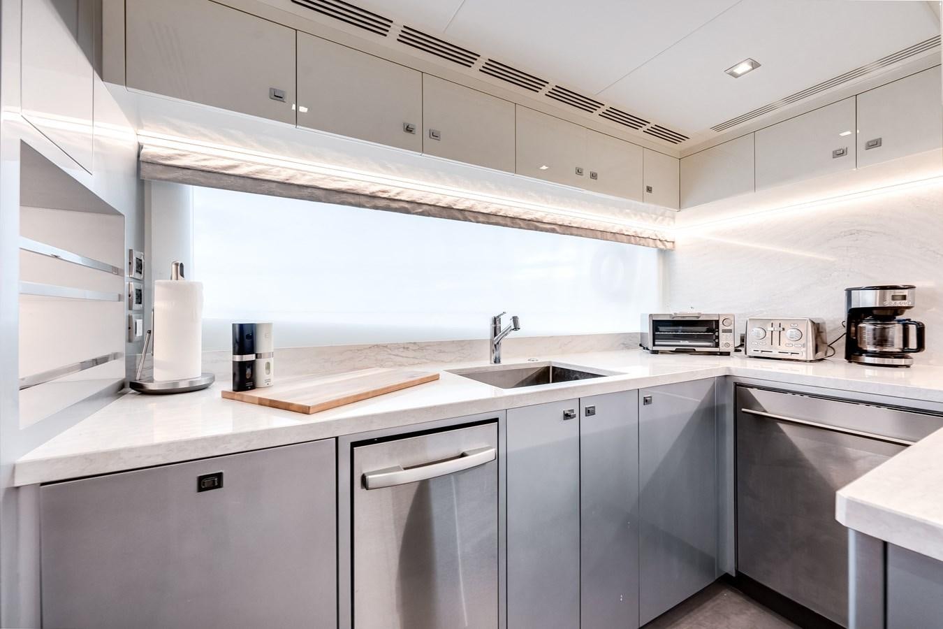 a kitchen with white cabinets aboard JUST A VACATION Yacht for Sale