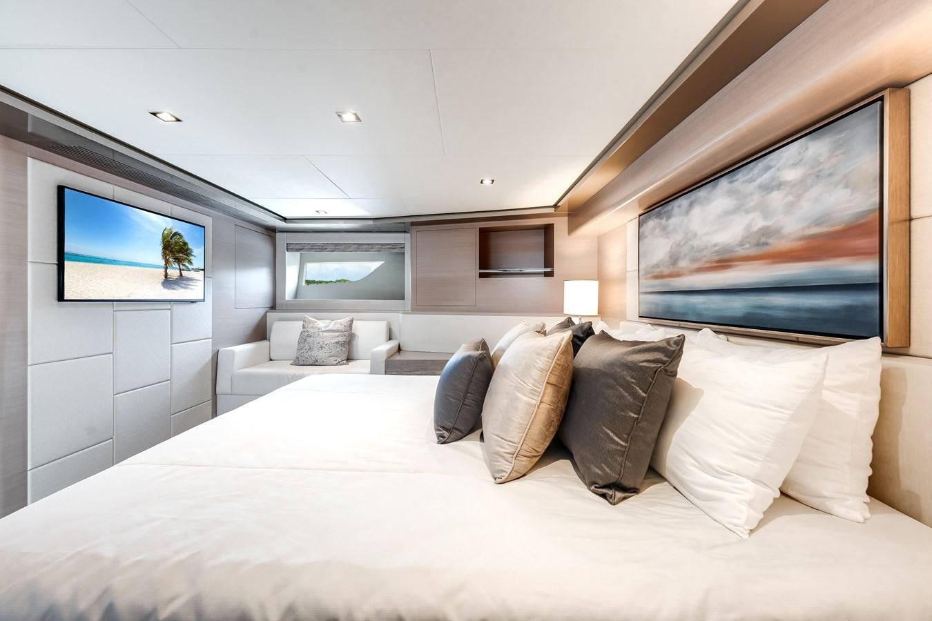 a bed with pillows and a painting on the wall aboard JUST A VACATION Yacht for Sale