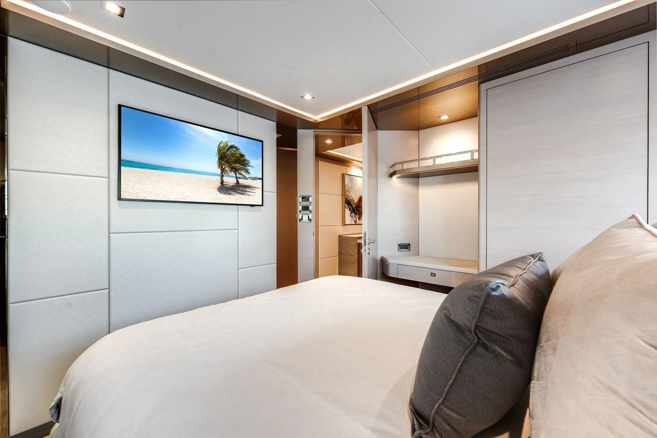 a bedroom with a bed and a television on the wall aboard JUST A VACATION Yacht for Sale