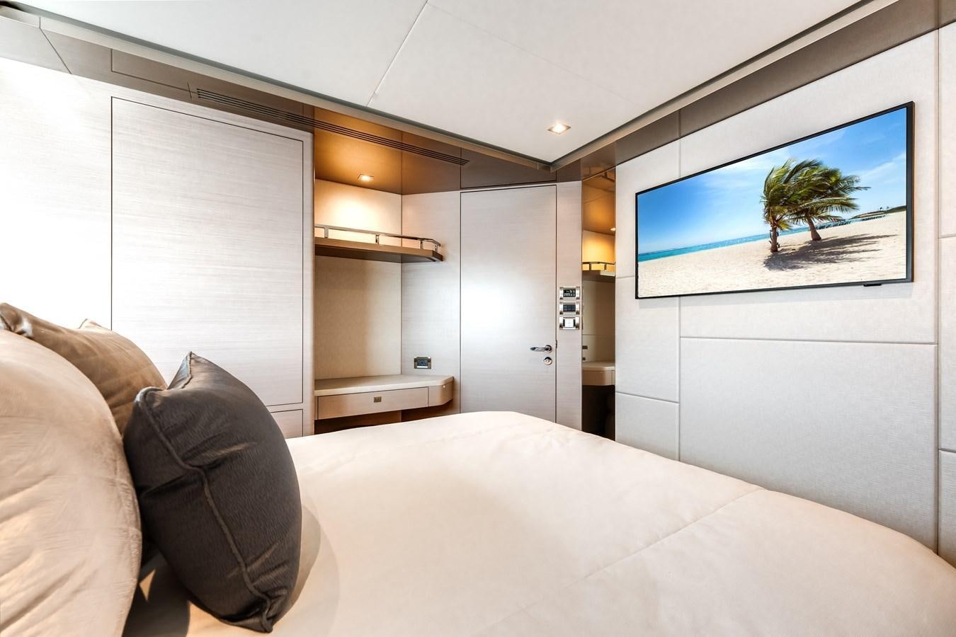 a room with a bed and a tv on the wall aboard JUST A VACATION Yacht for Sale