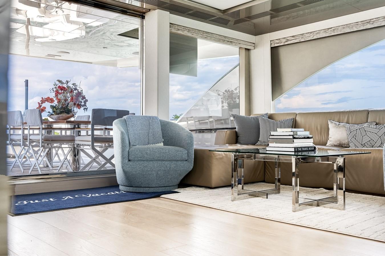 a living room with a blue couch and a table aboard JUST A VACATION Yacht for Sale