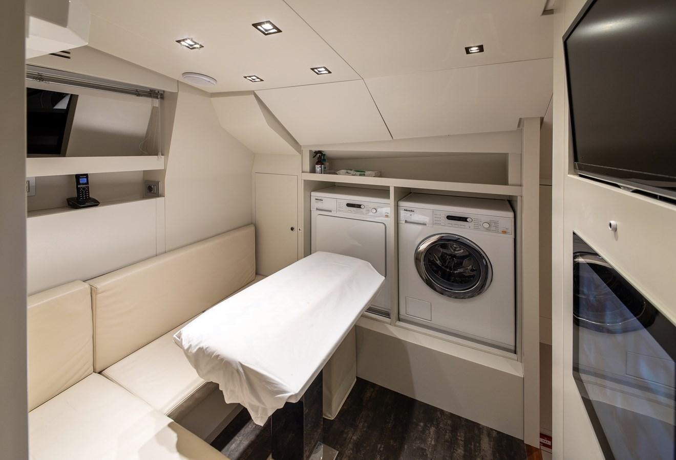 a room with a washing machine and a bed aboard CYBELE Yacht for Sale