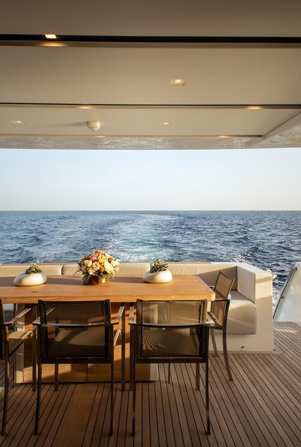 a table with chairs and a view of the ocean aboard CYBELE Yacht for Sale