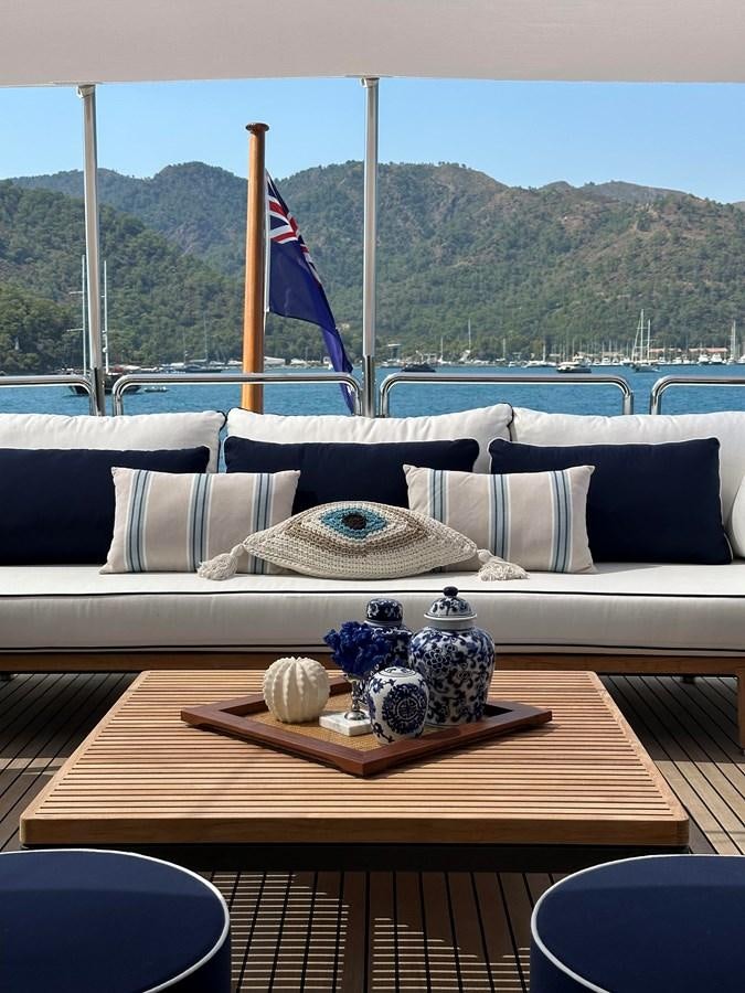 a couch with a blue and white striped pillow and a blue flag on it aboard FRIENDSHIP Yacht for Sale