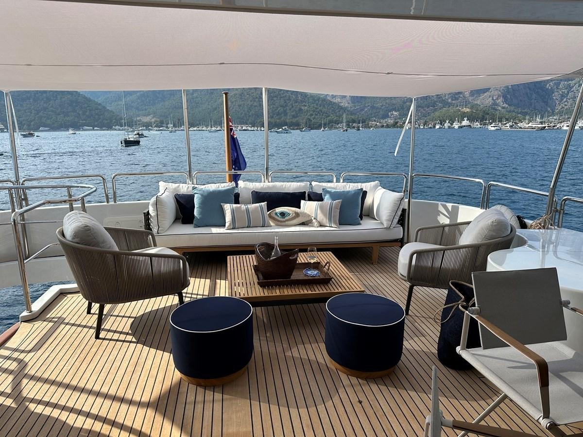 a table with chairs on it by a body of water aboard FRIENDSHIP Yacht for Sale