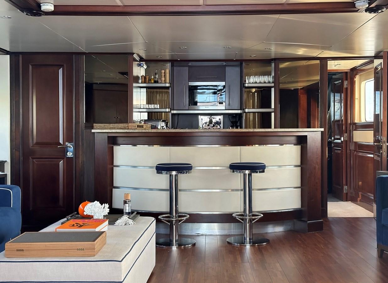a kitchen with a bar stools and a table aboard FRIENDSHIP Yacht for Sale