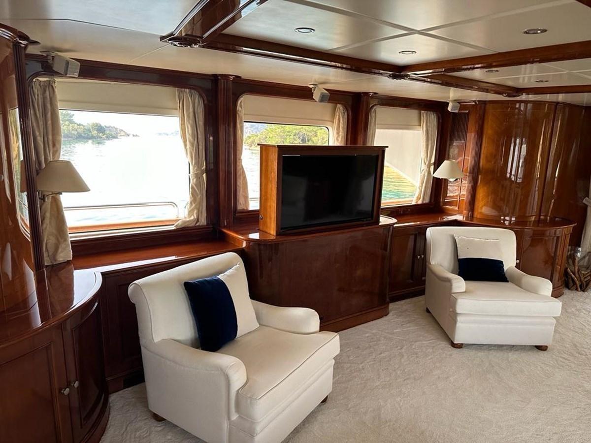 a living room with a tv and furniture aboard FRIENDSHIP Yacht for Sale