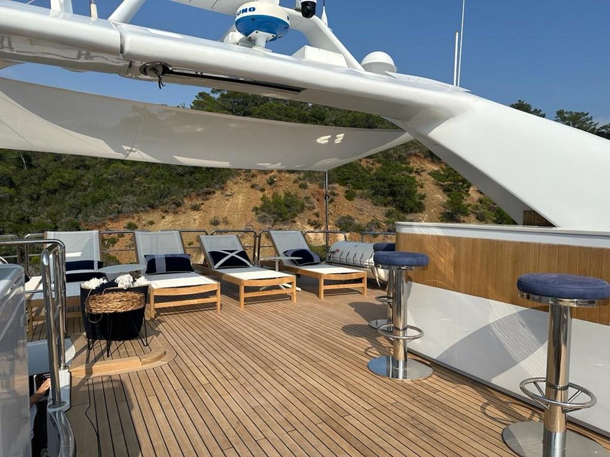 a deck with chairs and tables aboard FRIENDSHIP Yacht for Sale