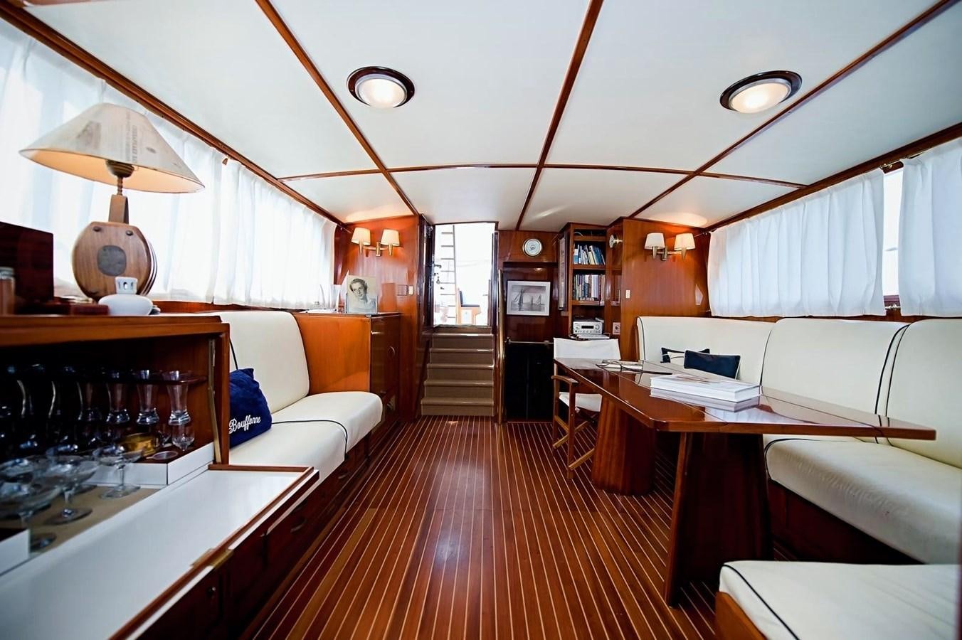 a room with a wood floor and a wood floor with white couches and a wood floor with aboard LA BOUFFONNE Yacht for Sale