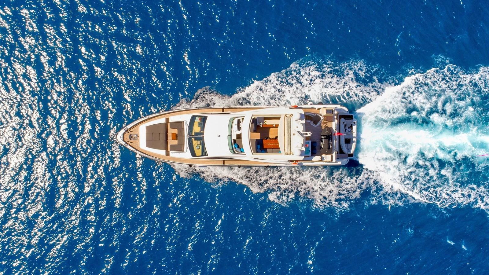 A stunning aerial view of a yacht cruising through vibrant blue waters. aboard HUBO Yacht for Sale
