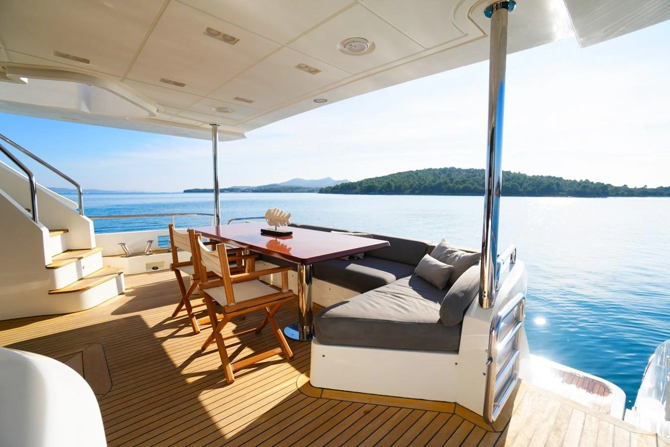 The aft deck offers a serene outdoor dining area with comfortable seating and stunning sea views. aboard HUBO Yacht for Sale