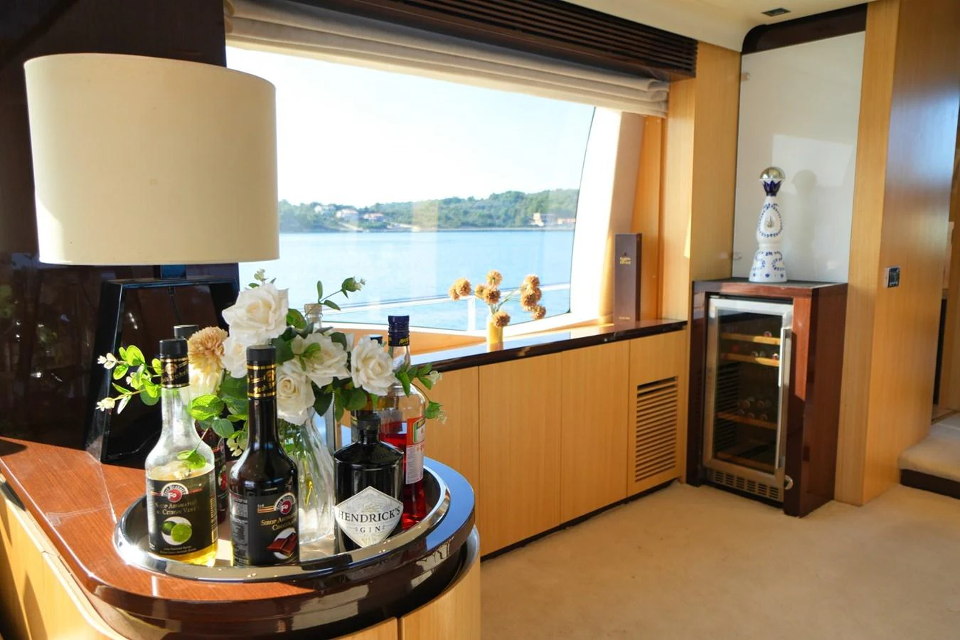 A well-appointed interior space featuring a bar area with a view of the water. aboard HUBO Yacht for Sale