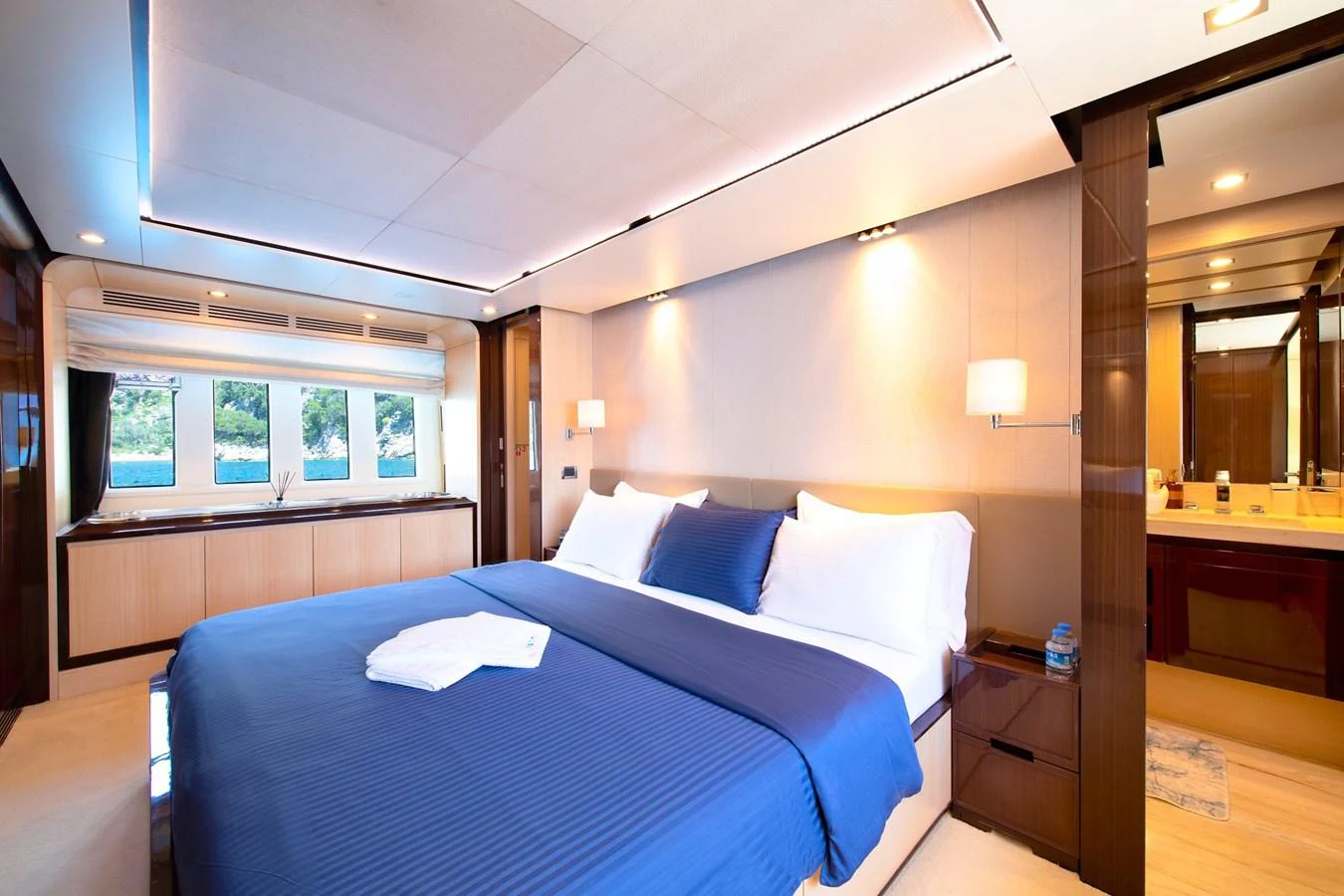 The master stateroom features a spacious bed with elegant bedding and ample natural light from the large windows. aboard HUBO Yacht for Sale